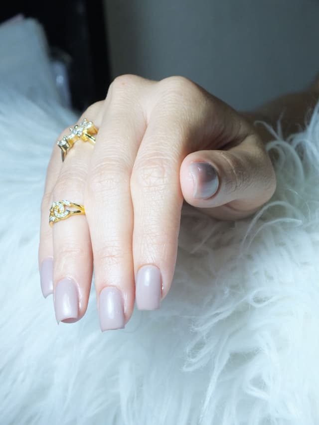 Uñas milky color leche sobre una textura blanca
