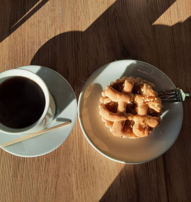 Croffle dorado junto a una taza de café