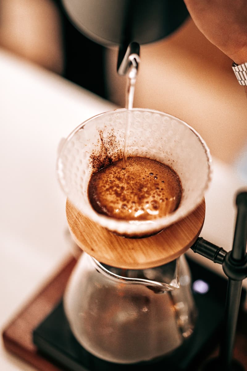 Agua caliente cayendo sobre café molido en un gotero, que empieza a burbujear